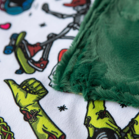 This minky baby lovie or baby security blanket features skeletons and zombie hands all over the blankie. this closeup shot shows the green minky back